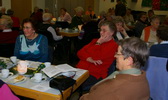 Foto: Seniorinnen sitzen am Tisch, essen Kuchen, lachen und unterhalten sich.